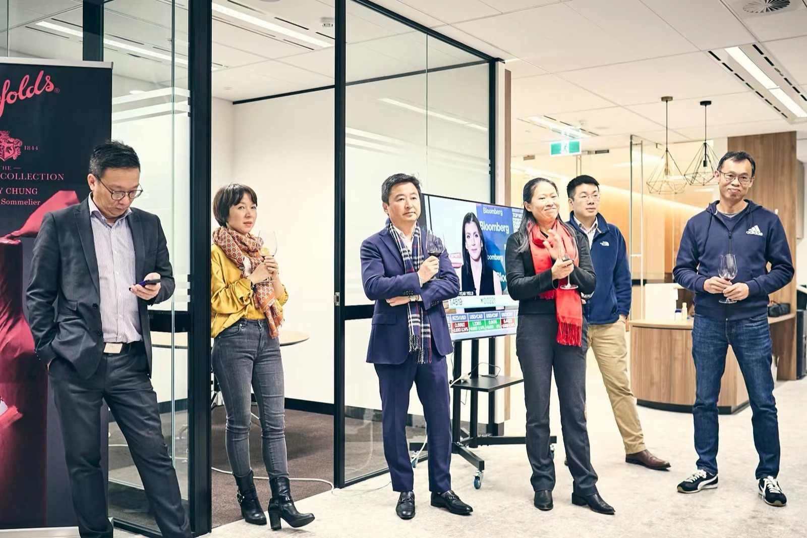 Adults at a business networking event with a wine tasting banner