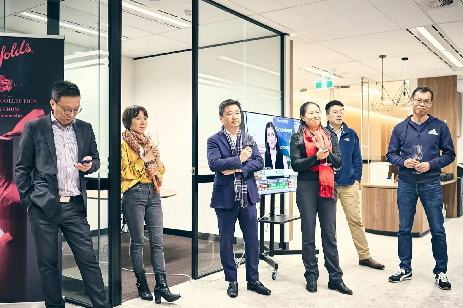 Adults at a business networking event with a wine tasting banner